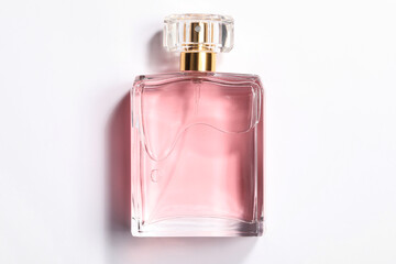 Pink women's perfume in bottle on white background, top view