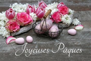 	Carte de voeux Joyeuses Pâques. Salutation de Pâques avec bouquet de fleurs et œufs de Pâques sur table en bois rustique.