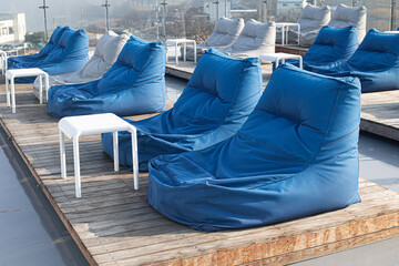 Side view of two soft blue large beanbags chairs isolated