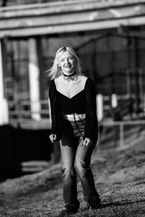 Portrait of a young beautiful blonde girl in a black coat. Black and white photo.