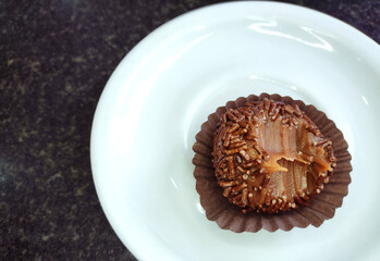 Traditional Brazilian sweet known as brigadeiro or Brazilian truffle bite, on the porcelain pyrex.
