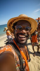 vertical selfie photo of african american tourist smiling at a paradise beach party. young man with sunglasses and orange t-shirt enjoying his vacation on a beach. - obrazy, fototapety, plakaty