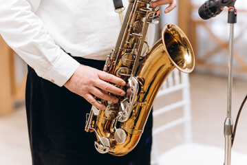 saxophonist musician plays saxophone on holiday, elderly caucasian man in white shirt - obrazy, fototapety, plakaty