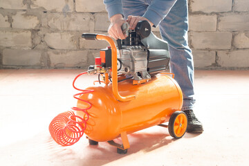 The compressor is portable.Using a portable compressor at work.