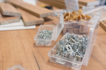 Cluttered workspace with tools and hardware on a wooden surface.