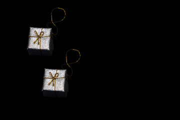 small silver-colored christmas presents on a black background