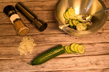 cut cucumber slices in a bowl next to a salt and pepper mill