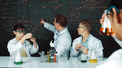 Smart teacher explain about chemical theory while student mixing colored solution or doing...