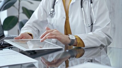 Doctor woman using tablet on the glass desk in medical office. Medicine and health care