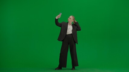 Portrait of female in suit on chroma key green screen. Blonde business woman in formal outfit...