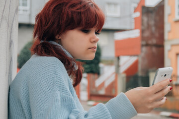 teenager girl using phone on the street