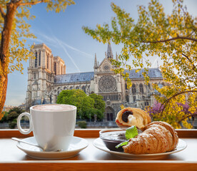 Coffee with croissants against cathedral Notre Dame in Paris, France - 762656854