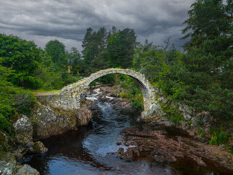 Mountain River Dulnain flowing under old rubble Carrbridge Packhorse Bridge