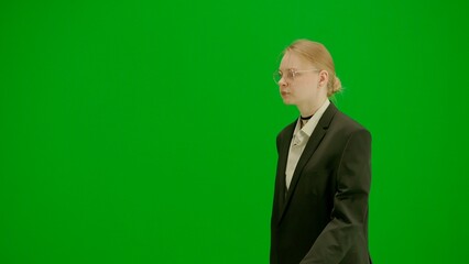 Portrait of female in suit on chroma key green screen. Blonde business woman in formal outfit...