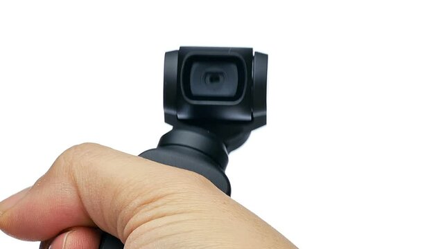 Closeup hand manoeuvring and control little ccompact amera with gimbal on white background