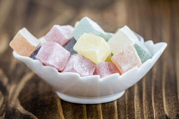 Colorful Turkish Delight in White Bowl on Wooden Background, Rustic Presentation of Multicolored Cube Shaped Sweets, Generative AI