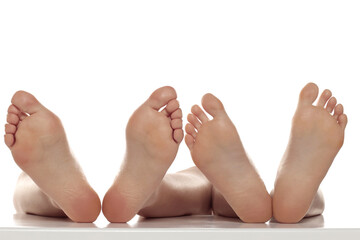Two pairs od a beautiful well-groomed women's sole feet close-up on a white isolated studio background, The concept of foot skin care. - obrazy, fototapety, plakaty