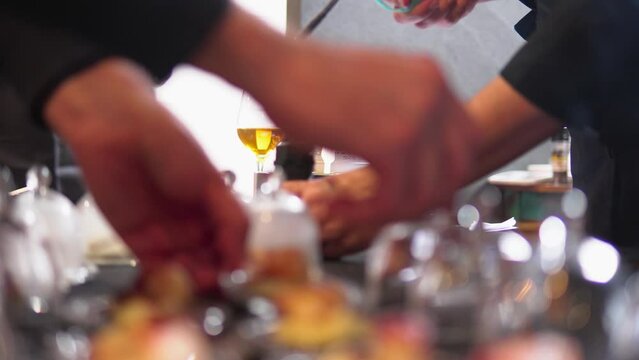 Professional chefs in a small business cooking with a smoke gun device to flavor tapas in glass domes.