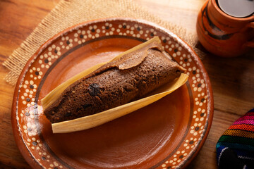 Chocolate Tamale. hispanic dish typical of Mexico and some Latin American countries. Corn dough wrapped in corn leaves. The tamales are steamed. Usually accompanied with atole, hot chocolate or coffee - 762675691