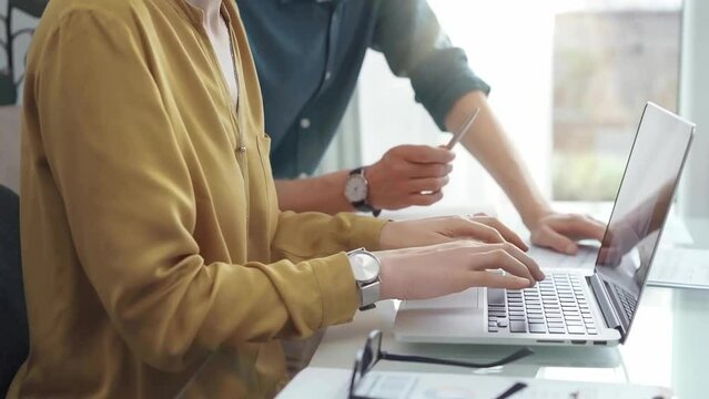 Business professionals analyzing financial reports. Casual dressed business people discussing financial data and reports while sitting at the glass desk in office
