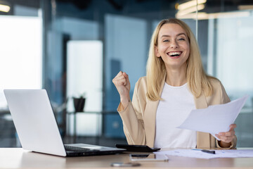 Successful businesswoman celebrating a victory at work