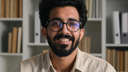 Cheerful Arabian man businessman teacher tutor male business portrait of happy Indian guy candid smile smart graduate student in eyeglasses at university class home office library bookshelf background