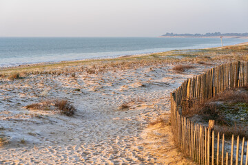 Fototapeta na wymiar Idyllic sandy beach on Ile de Re, Charente-Maritime, France. Beautiful sunrise light on a cold day.