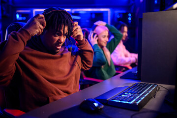 African american male gamer playing video game and having fun with his friends