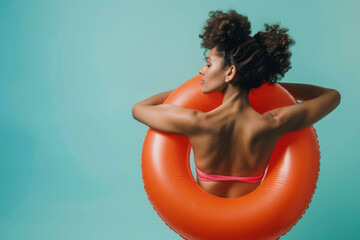 A woman in a bikini posing with an inflatable pool ring float. Summer holiday lifestyle