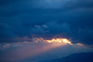 Fototapeta na wymiar 垂れ込めた雲の間から差す夕方の光