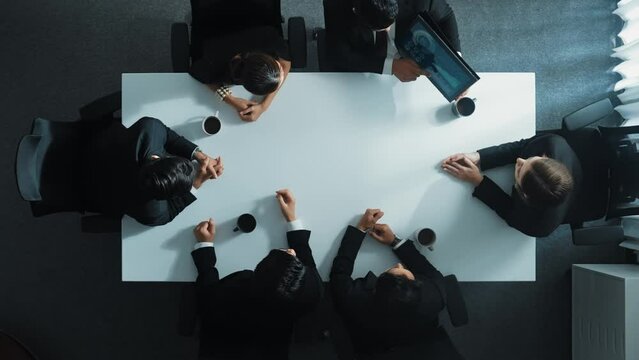 Time Lapse Of Professional Business Team Discuss And Analyze Data. Top Down Aerial Of Group Of Diverse People Brainstorm Marketing Idea While Looking At Financial Graph At Meeting Table. Directorate.