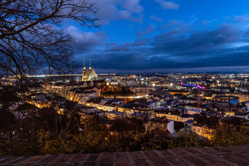 Brno, Czech Republic - Night city panorama with illuminated streets and cathedral with tall towers in the center of the city. Evening street with street lights.