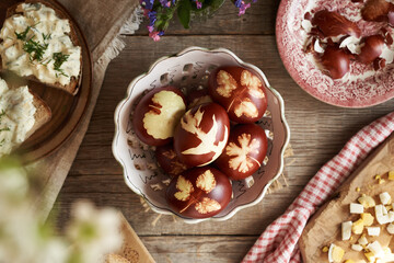 Brown Easter eggs dyed with onion skins, with slices of sourdough bread with spread made of...