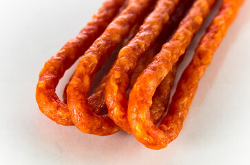 Many thin sausages on a white background
