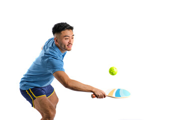 young oriental boy in blue sportswear playing pickleball on white background