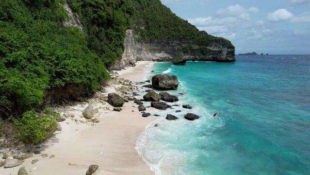 Forward reveal drone fotage of empty Suwehan Beach on sunny day. Nusa Penida Island, Indonesia.