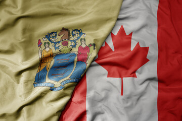 big waving realistic national colorful flag of new jersey state and national flag of canada .