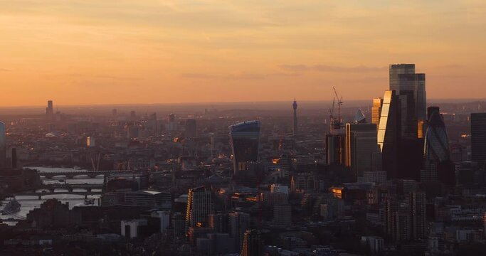Elevated, panned view of the urban London skyline from the City to London Bridge during a colorfur sunset