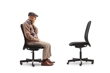 Elderly man sitting on a desk chair opposite an empty chair