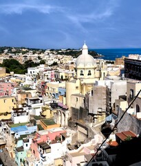 Panoramic view of beautiful Procida in sunny summer day. Colorful houses, fishing boats and yachts...