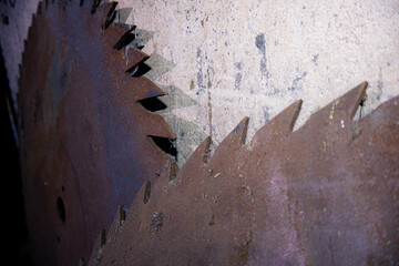 Nahaufnahme von zwei alten, rostigen, staubigen, großen Sägeblätter die an einer Wand lehnen