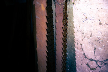 Nahaufnahme von alten, rostigen, staubigen, großen Sägeblätter die an einer Wand lehnen