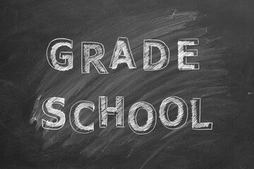 Lettering GRADE SCHOOL on a black chalkboard