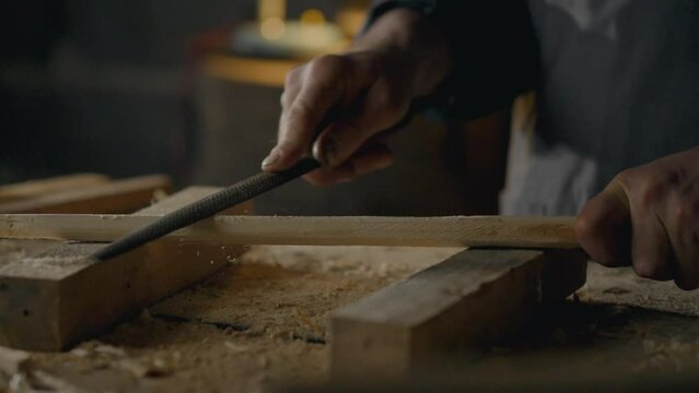 A woodworker works in a furniture making workshop, The process of processing wood with special hand carpentry tools, A master carpenter works with wood creating custom-made products