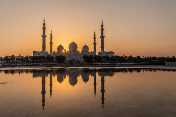 Fototapeta na wymiar Sunset behind Sheikh Zayed Grand Mosque in Abu Dhabi, United Arab Emirates.