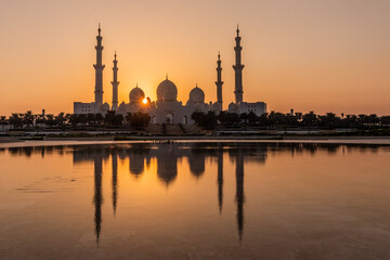 Fototapeta na wymiar Sunset behind Sheikh Zayed Grand Mosque in Abu Dhabi, United Arab Emirates.