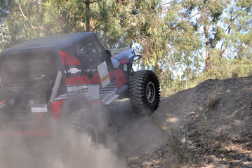 Off-road car climbing a dirt ramp on a mountain trail, action and adventure on four wheels