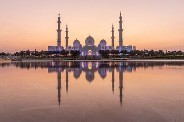 Fototapeta na wymiar Evening view of Sheikh Zayed Grand Mosque in Abu Dhabi reflecting in a water, United Arab Emirates.