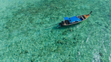 Traditional Thai longtail boat in the shallow waters of Phi Phi island, Krabi, Thailand. Boat tour in South East Asia concept.