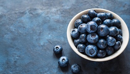 blueberries in a bowl minimal dark blue background with copy space